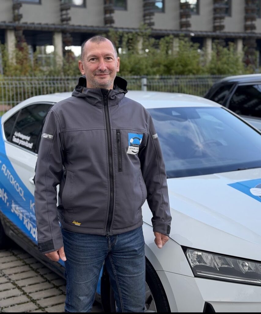 Autokool Kindel Rooli sõiduõpetaja Alexey Katuntsev kooli õppeauto kõrval